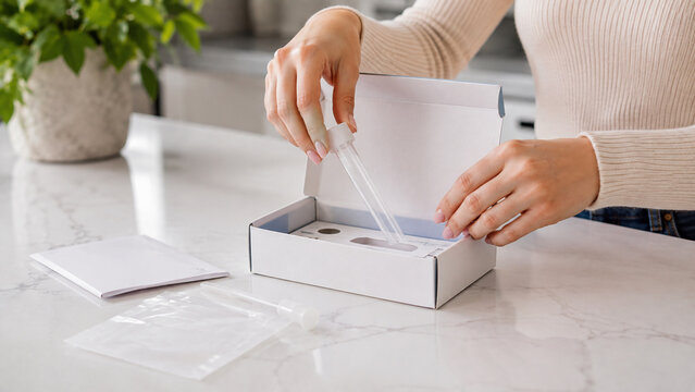 Home DNA test kit with person collecting saliva sample for genetic health analysis and laboratory testing
