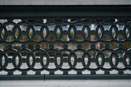 Decorative cast iron railing with geometric pattern on a historic heritage building.