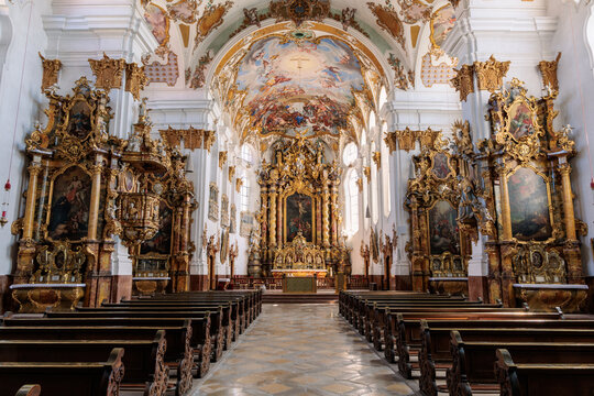 Symmetrical interior view of church Mari&auml; Himmelfahrt with golden baroque altar, ornate pulpit and ceiling frescoes in Landsberg am Lech, Germany