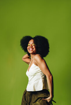 Smiling woman stands with confidence in a vibrant studio portrait