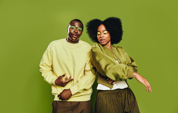 Fashion-forward friends pose as a dance duo in a studio portrait with playful energy