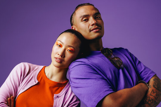 Lifestyle portrait of friends leaning together bringing a colorful studio scene to life