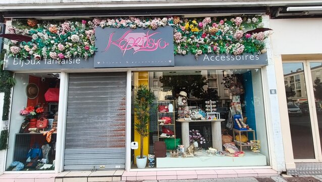 Royan, France - July 15, 2026: Charente-Maritime. Nouvelle-Aquitaine. Flower-adorned storefront of Kapristo accessories shop with decorative items and colorful displays in urban setting