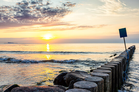 A picturesque sunset on the sea shore with a breakwater
