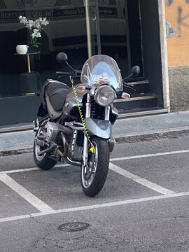 BMW R 1150 R motorcycle parked on a city street, featuring its distinctive boxer engine and disk lock for security