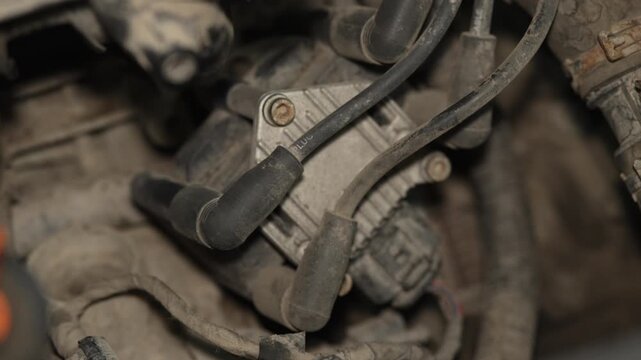 Dusty ignition coil pack with spark plug wires in engine.