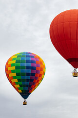 Fototapeta premium Colorful hot air balloons flying in cloudy sky during festival, outdoor adventure travel background.