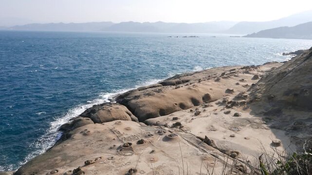 Wonderful odd rock shore, smooth and eroded, panoramic shot at end point of Yehliu Geopark cape, downstairs to East side. Unusual unreal landscape created by volcanic formation and years of weathering