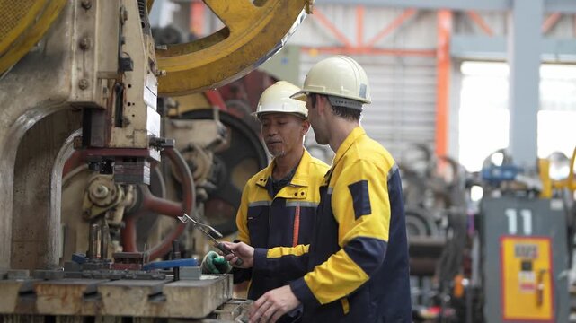 Workers in a manufacturing plant using machinery to assemble parts in the daytime