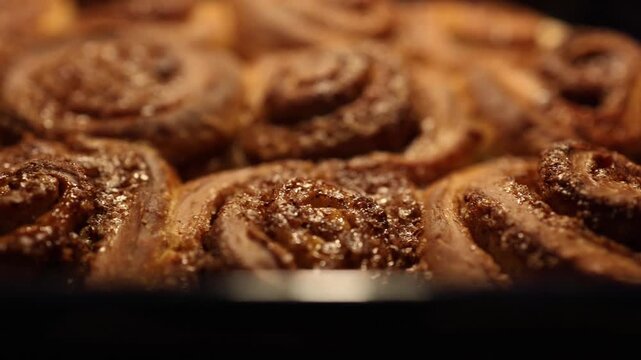 Fresh cinnamon rolls baking in the oven. Warm, sweet pastries with cinnamon and sugar aroma, perfect for breakfast or dessert.