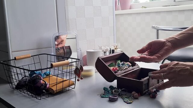 Sorting and organizing jewelry in a simple workspace with a wooden box and baskets