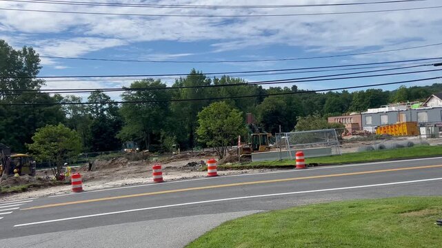 Construction site with heavy machinery and road traffic