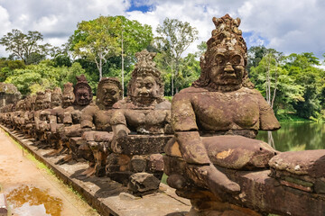 Fototapeta premium Ancient stone guardian statues lining the causeway at the South Gate of Angkor Thom in Siem Reap, Cambodia
