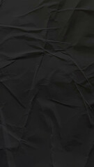 Fototapeta premium Crumpled black textured background, perfect for a sleek mobile wallpaper.