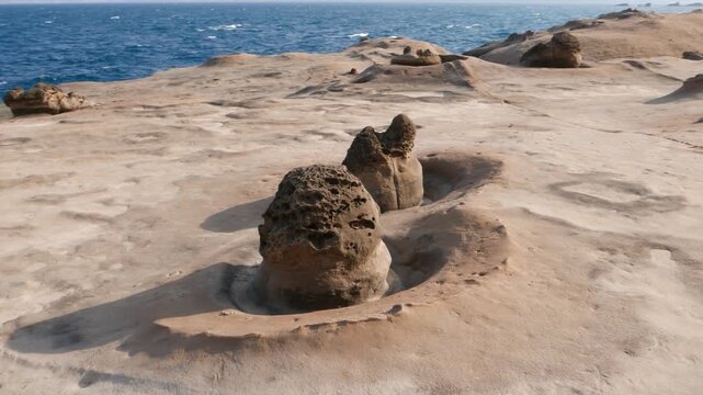 Small mushroom weathered stone at deserted Yehliu shore, parallax shot. Low evening sun light, flat smooth area, washed by waves and rains, hard cap on small odd stone formation