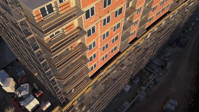building facade with mineral wool insulation, Drone flight view. wool panels are being fixed to the facade  multi-story residential building undergoing exterior thermal insulation.