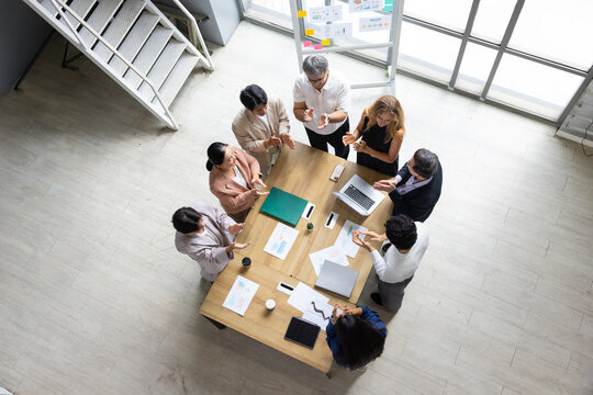 Top view success business people meeting with high five, celebration. working at office. Professional business teamwork diverse company. Achievement or celebration, motivation and clapping hands