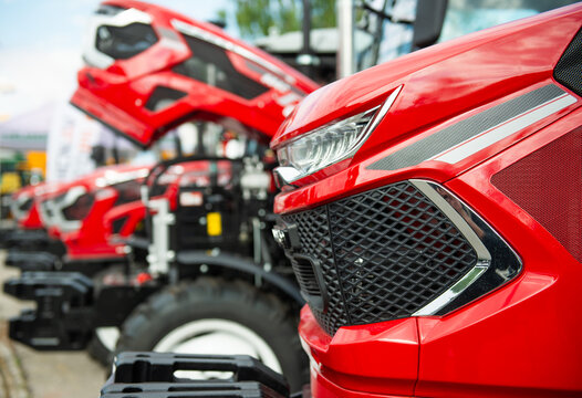 Close-up of modern red agricultural tractors at farm machinery exhibition