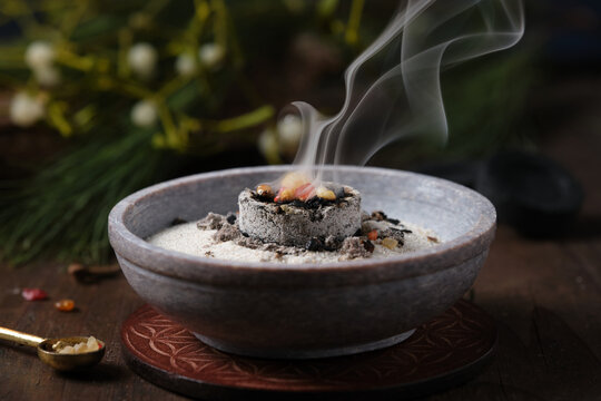 Frankincense, resins and dried herbs burning on glowing charcoal - incense ritual on Yule