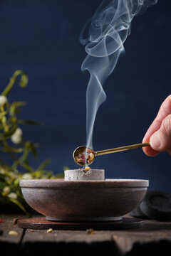 Incense ritual on Yule - placing frankincense with a spoon on a glowing incense charcoal