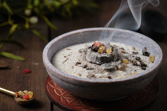 Frankincense, resins and dried herbs burning on glowing charcoal - incense ritual on Yule