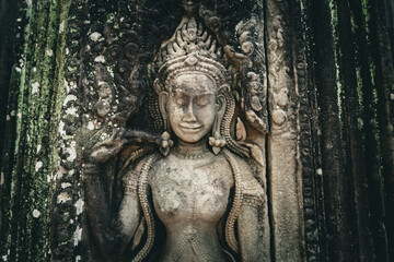 Fototapeta premium Ancient stone carving of a female Apsara dancer inside Angkor Wat temple in Siem Reap, Cambodia
