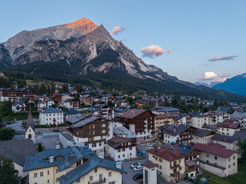 Aerial view of the alpine village of San Vito di Cadore nestled in the Dolomites with traditional architecture, a historic church, and mountain peaks in San Vito di Cadore, Veneto, Italy.