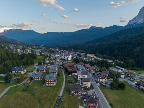 Aerial view of the alpine village of San Vito di Cadore in the Dolomites with historic church, traditional houses, and green meadows in San Vito di Cadore, Veneto, Italy.