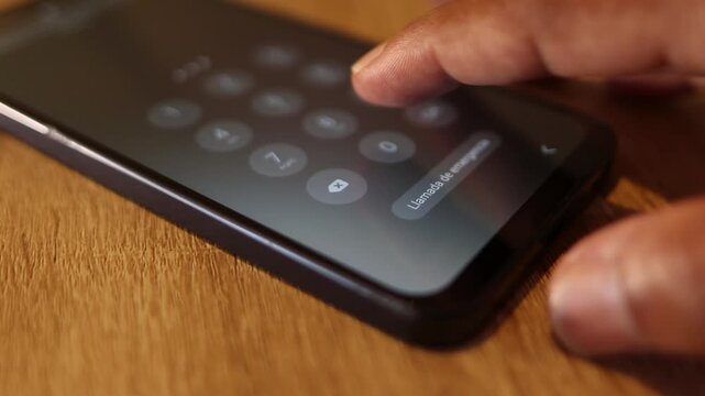 Close up of a person unlocking smartphone by entering the pin code on the touchscreen keyboard for digital security