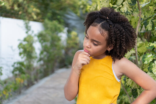 Young girl thinking looking away in garden
