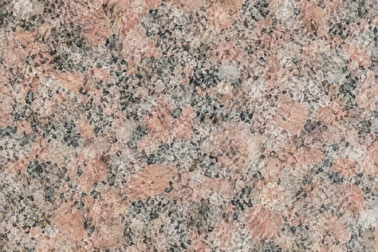 Seamless detailed close up of a polished pink granite surface showcasing its distinctive granular texture.