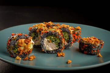 Crispy tempura crunchy sushi rolls served on round blue plate © Ilias