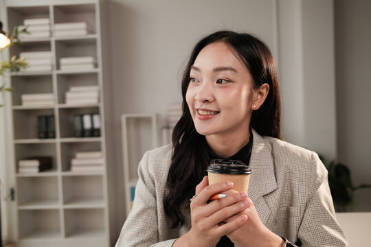 Young businesswoman smiling holding coffee cup in office