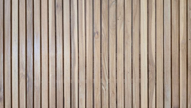 Natural light brown wood slat wall texture background. Close-up of vertical timber slats wall backdrop, showcasing neat lines and organic wood grain.