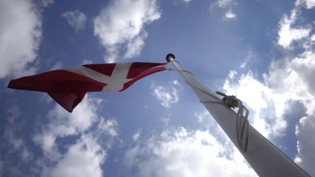 Hirtshals, Denmark A Danish flag flies on a flagpole.