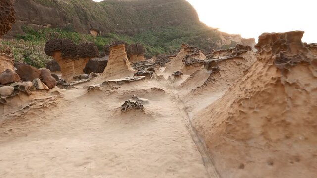 Fantastic landscape of mushroom rock group, long POV move shot, iconic field of Yehliu Geological Park. Soft evening light, first person view camera walk forward along unreal hoodoo stones landscape.