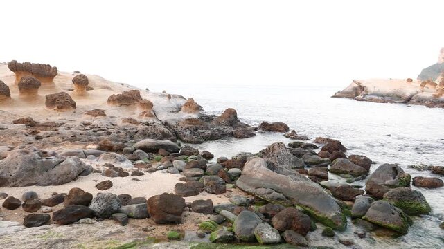 East China Sea waters, small bay aside Mushroom rock group at Yehliu Geopark, Taiwan. Evening light, pan panoramic shot of geopark shore. Yeh-Liou is cape on north coast of Taiwan