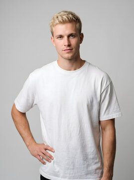 Young blonde man wearing plain white tshirt standing in studio.
