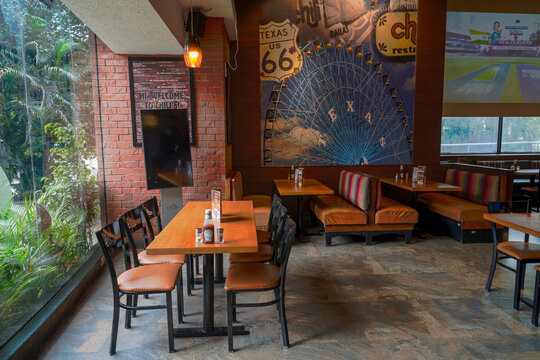 A cozy, casual interior of an American style restaurant featuring wooden tables, leather booths, and murals, ideal for food industry and hospitality marketing.