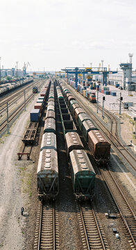 Vertical view of rows of covered freight wagons standing on parallel railway tracks in an organized industrial cargo terminal