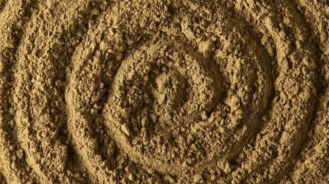 Close-up hojicha powder slowly rotates in circular pattern, revealing roasted tea texture for food and beverage backgrounds.