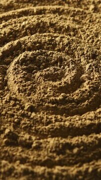 Close-up hojicha powder slowly rotates in spiral pattern and shows roasted tea texture for food, drink and background use.