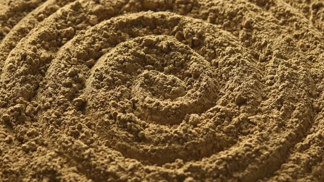 Close-up hojicha powder slowly rotates in spiral pattern, showing roasted tea texture for food, beverage and background use.