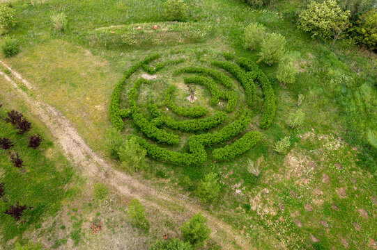Aerial view of the circular hedge maze at Ada Huja park surrounded by lush green grass and trees in Belgrade, City of Belgrade, Serbia.