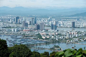 Fototapeta premium Panoramic photograph of Da Nang city skyline and coastline viewed from the back ridge of Son Tra peninsula with copy space
