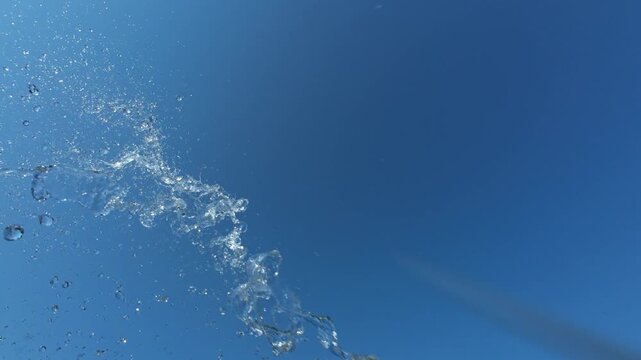 Fresh Water Splash Bursting From Left Side Against Bright Blue Sky