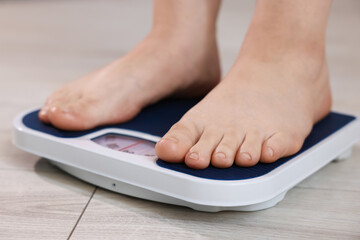 Fototapeta premium Overweight woman on scale at home, closeup