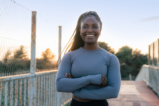 Smiling athlete standing on bridge 