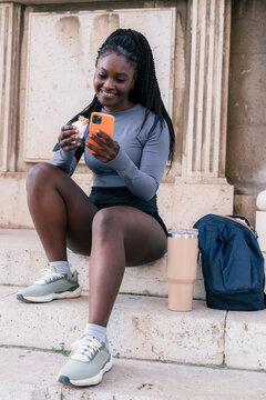 Woman texting messages and eating protein bar 