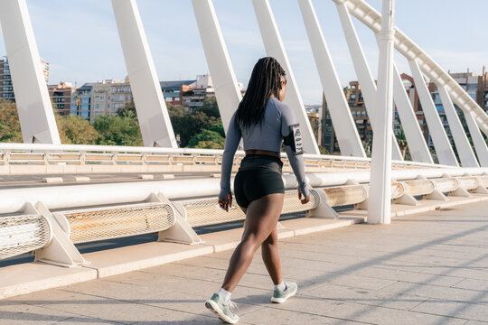 Woman walking across the bridge after workout 